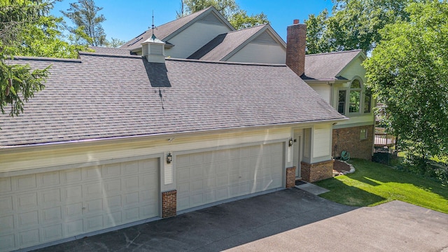 view of property exterior featuring concrete driveway, a chimney, roof with shingles, a yard, and brick siding