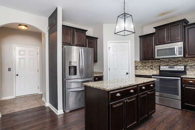 kitchen with arched walkways, backsplash, stainless steel appliances, and dark wood-type flooring