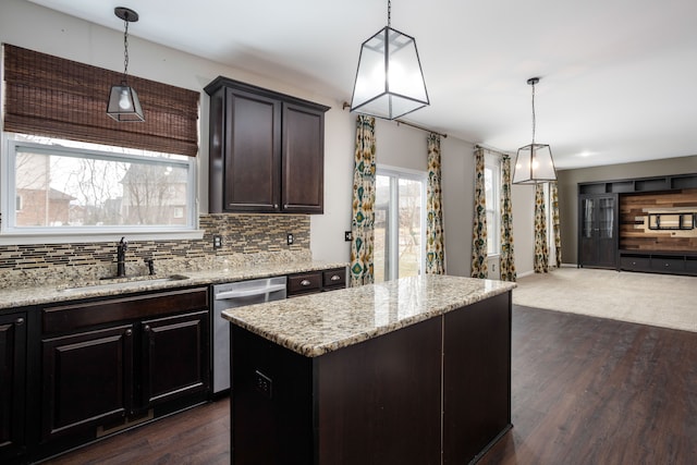 kitchen with a sink, backsplash, dark wood finished floors, a center island, and dishwasher