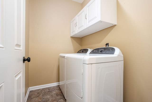 laundry area with washer and dryer, baseboards, cabinet space, and stone finish flooring