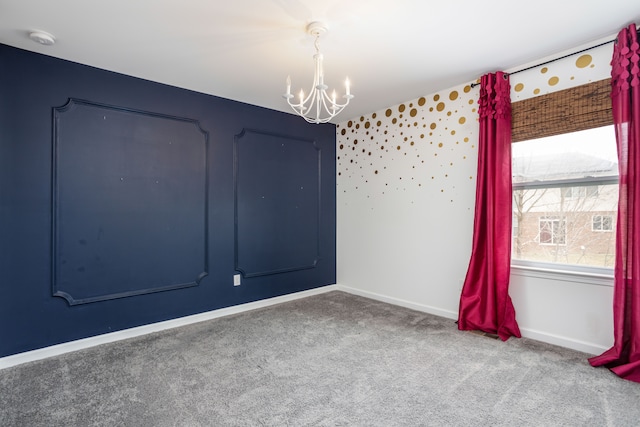 carpeted spare room with baseboards and an inviting chandelier