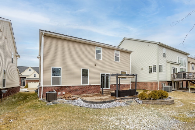 back of property featuring a pergola, central AC, a yard, brick siding, and a patio area