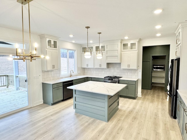 kitchen with stainless steel range with gas cooktop, tasteful backsplash, gray cabinetry, freestanding refrigerator, and dishwasher