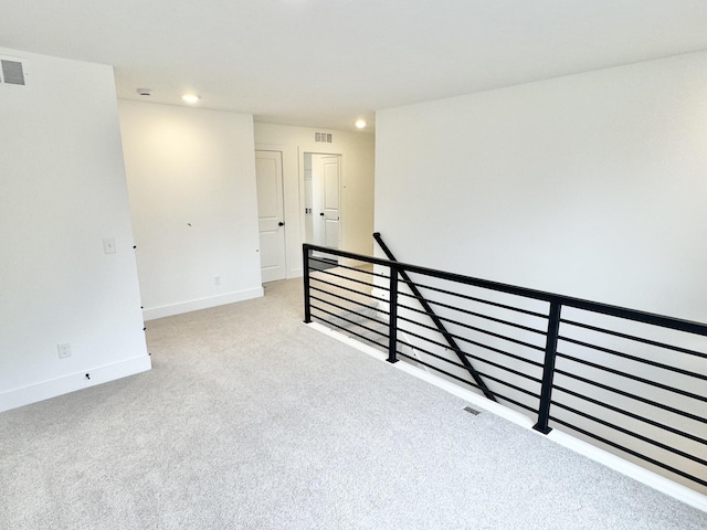 empty room featuring carpet floors, baseboards, visible vents, and recessed lighting