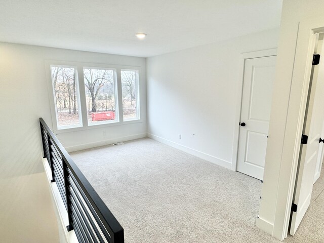 interior space featuring carpet floors, visible vents, and baseboards