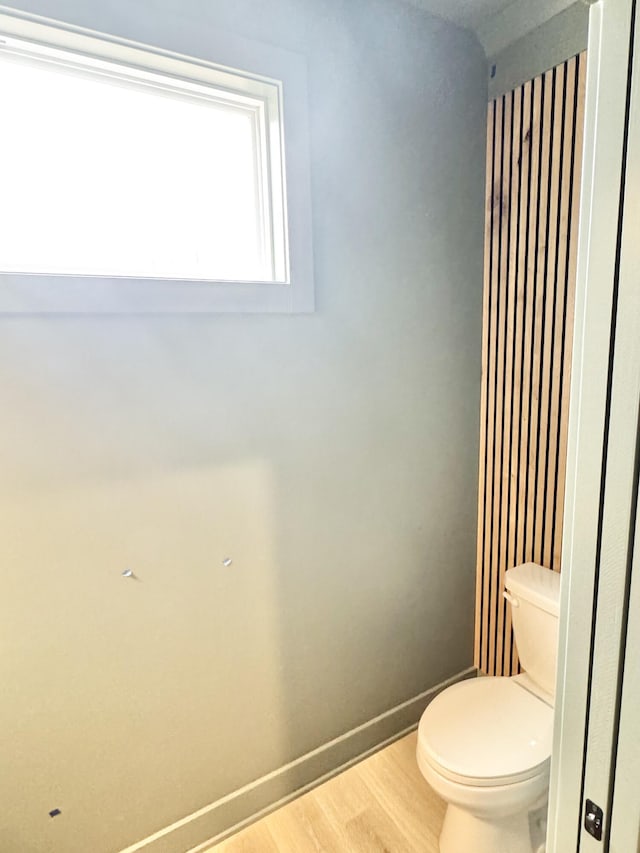 bathroom featuring wood finished floors, toilet, and baseboards