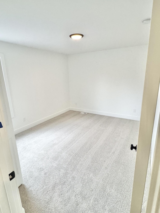 carpeted spare room with baseboards