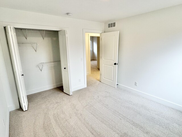 unfurnished bedroom featuring carpet floors, a closet, visible vents, and baseboards