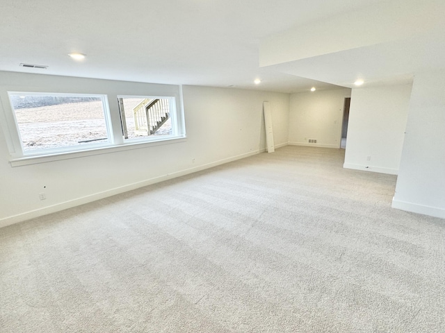 below grade area with recessed lighting, visible vents, baseboards, and light colored carpet