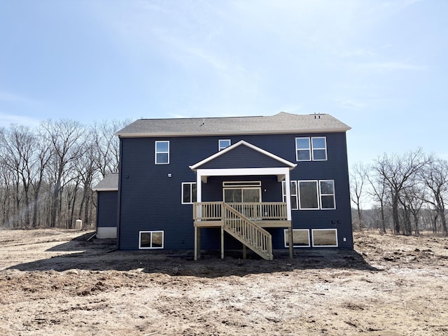 rear view of property featuring stairs and a wooden deck