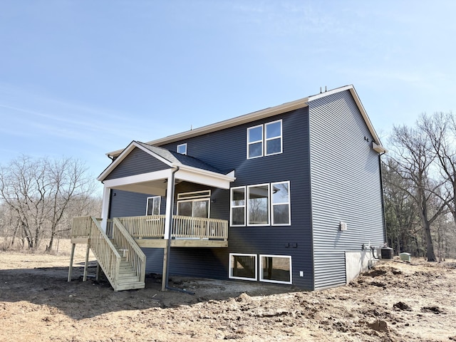 back of house featuring stairs and a deck