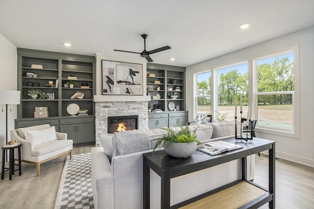 7711 96th St SE, Alto, MI 49302 - living area featuring plenty of natural light, a ceiling fan, a stone fireplace, light wood-style floors, and recessed lighting