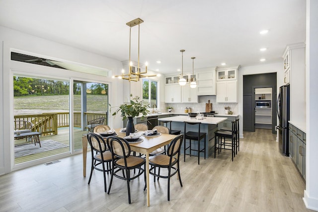 7711 96th St SE, Alto, MI 49302 - dining area with light wood-style flooring, a chandelier, and recessed lighting