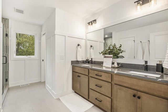 7711 96th St SE, Alto, MI 49302 - full bathroom featuring double vanity, a decorative wall, a shower stall, and tile patterned floors
