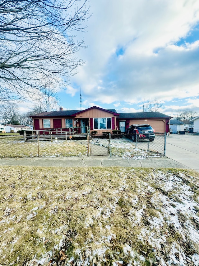 view of front of house with concrete driveway, a gate, and a fenced front yard