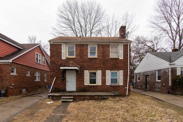 view of front of house featuring brick siding and a chimney