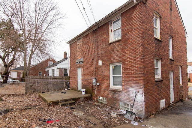 back of property featuring brick siding and fence