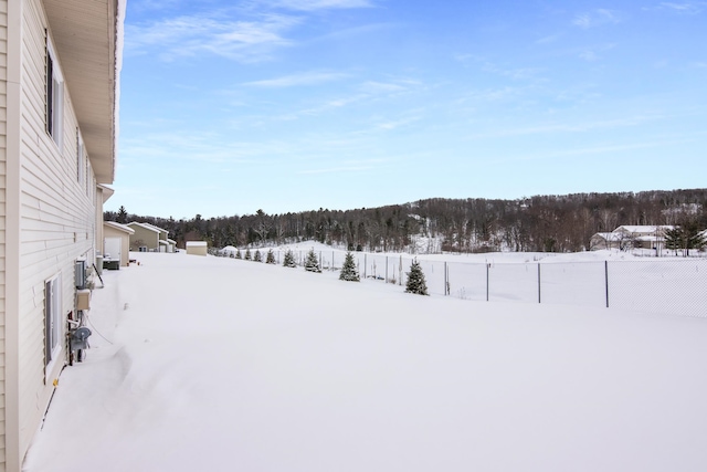 snowy yard featuring fence