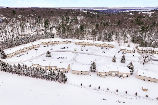 snowy aerial view featuring a wooded view