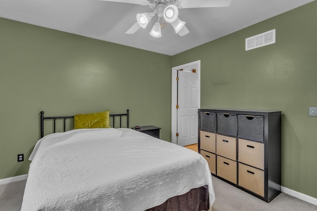 bedroom with ceiling fan, light colored carpet, visible vents, and baseboards