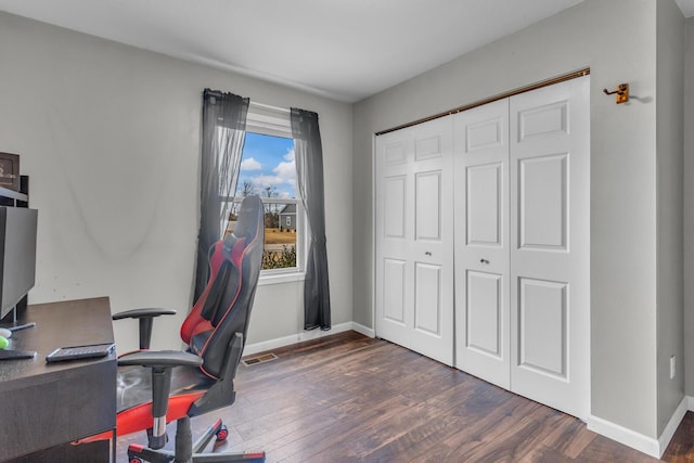 office space featuring wood finished floors, visible vents, and baseboards