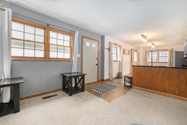 entrance foyer with carpet, visible vents, and baseboards