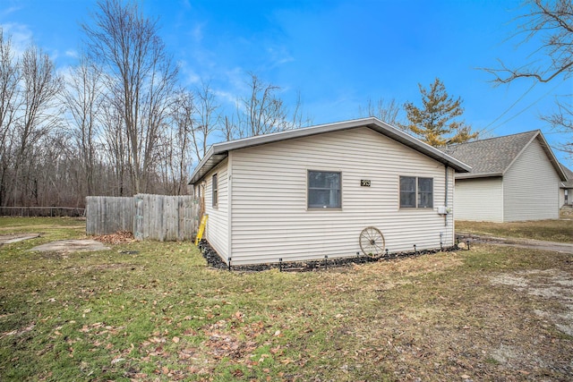 view of property exterior featuring a yard and fence