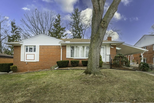 view of front of home featuring a front yard, a chimney, and brick siding