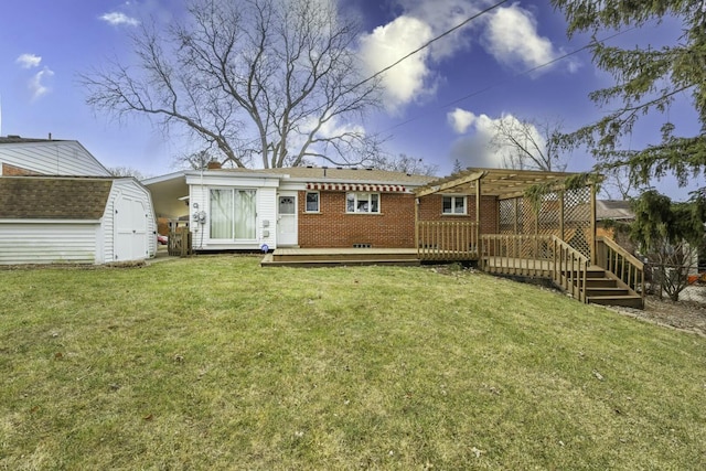 rear view of property featuring an outbuilding, brick siding, a yard, a deck, and a shed