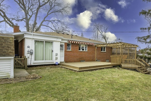 rear view of house with brick siding, a lawn, a chimney, and a wooden deck