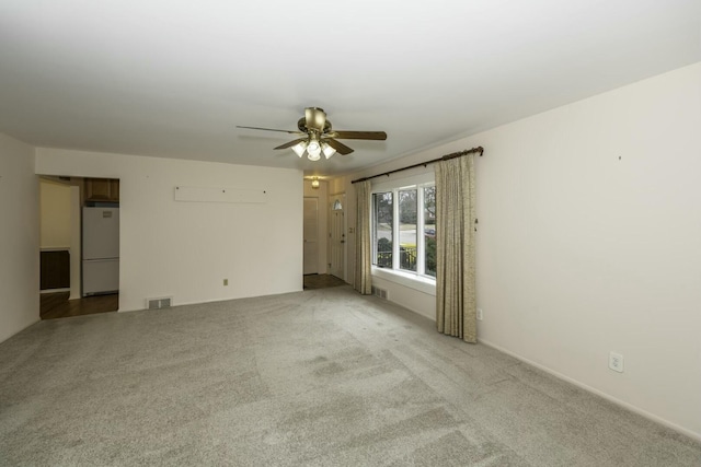 unfurnished room featuring a ceiling fan, visible vents, and light carpet