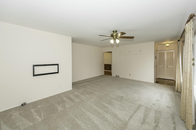 unfurnished living room featuring carpet and a ceiling fan