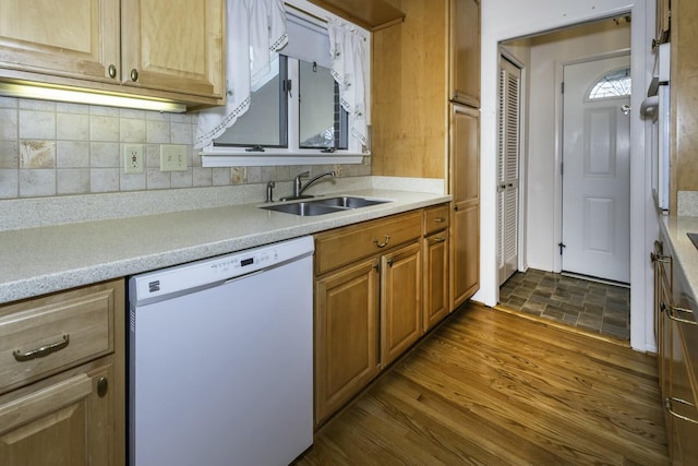 kitchen featuring tasteful backsplash, white dishwasher, light countertops, and a sink