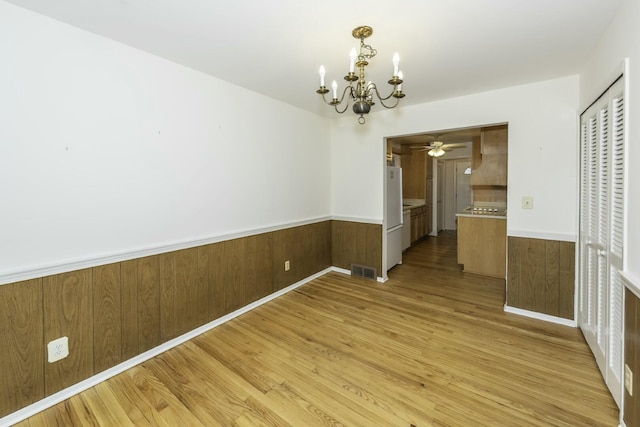 unfurnished dining area with light wood finished floors, visible vents, and wainscoting