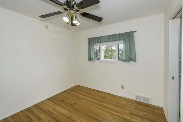 empty room with visible vents, baseboards, and wood finished floors