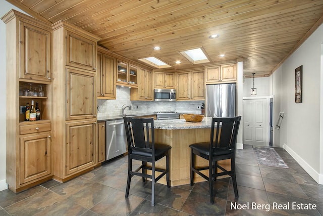 kitchen featuring wooden ceiling, stainless steel appliances, a skylight, backsplash, and light stone countertops