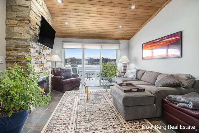 living room featuring lofted ceiling, wood ceiling, a healthy amount of sunlight, and a stone fireplace