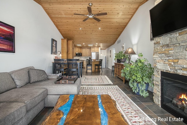 living room with visible vents, a ceiling fan, a stone fireplace, high vaulted ceiling, and wooden ceiling