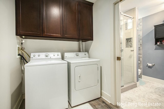 washroom with light wood finished floors, washing machine and clothes dryer, cabinet space, and baseboards