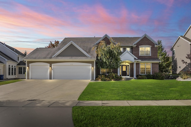 view of front of house featuring a garage, driveway, a front lawn, and brick siding