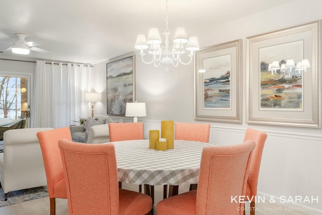 dining space featuring ceiling fan with notable chandelier