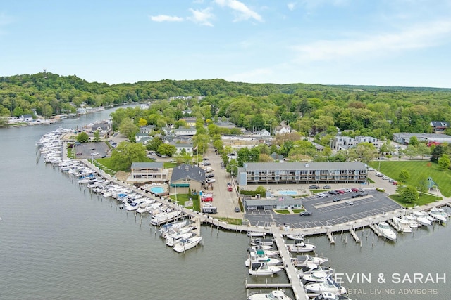 birds eye view of property with a water view and a wooded view