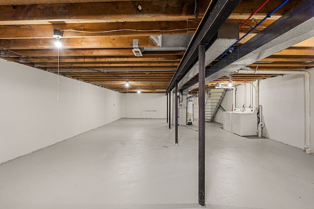 unfinished below grade area featuring water heater and independent washer and dryer