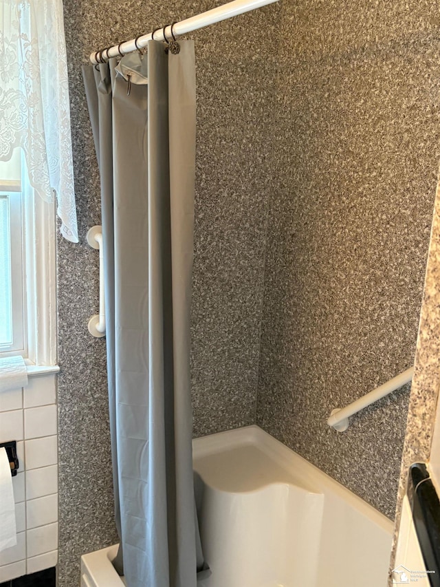 full bathroom with curtained shower and tile walls