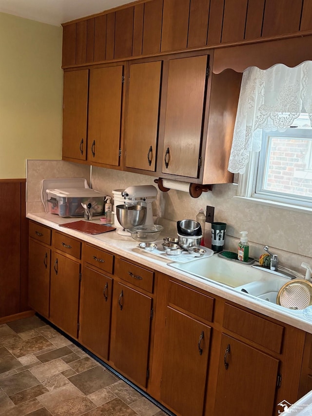 kitchen featuring brown cabinetry, light countertops, and a sink