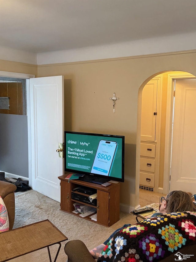 carpeted living room featuring arched walkways