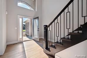 entrance foyer with stairway, a high ceiling, and wood finished floors