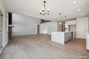 kitchen featuring pendant lighting, light countertops, light wood-type flooring, and baseboards