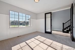 unfurnished room featuring carpet floors and stairway