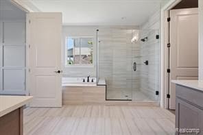 full bath featuring a shower stall, a washtub, and vanity